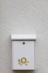 weißer Postkasten an einer weißen Wand