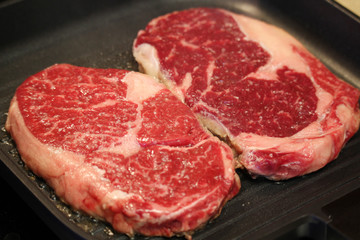 Raw steaks cooked on the pan