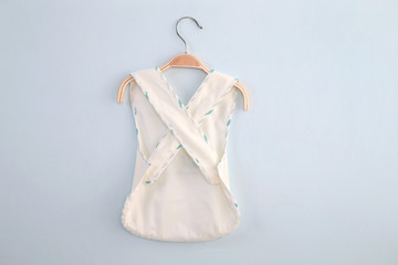 white cardigan kids shirt back view in clothes hanger, isolated on white background.