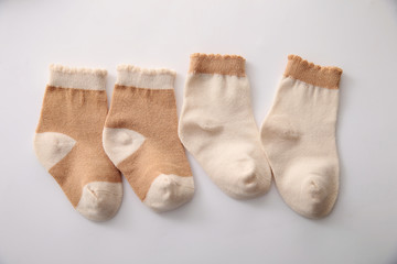 Baby socks hanging on the clothesline on wooden background