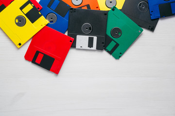 Vintage multi-colored floppy disk on white background. Flat lay copyspace.