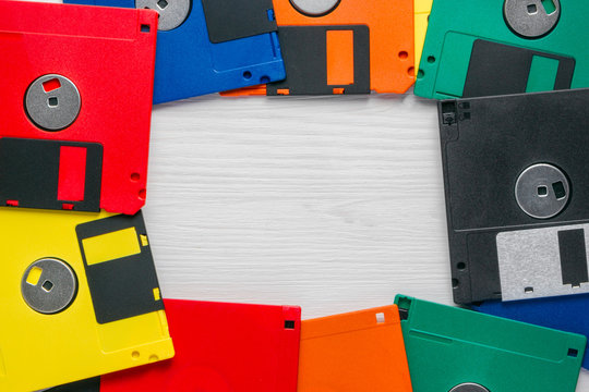 Vintage multi-colored floppy disk on white background. Flat lay copyspace.