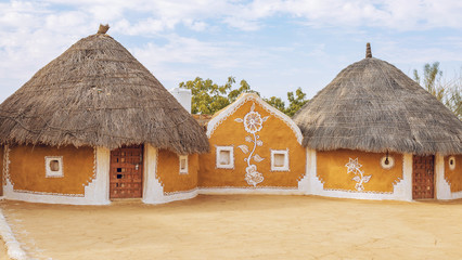 Rajasthan village near Thar desert Jaisalmer with mud huts and painted walls.