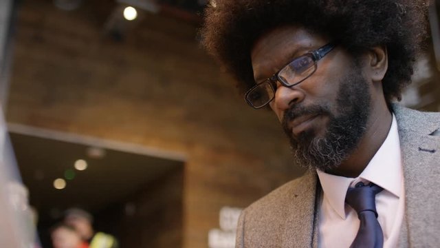 Confident Black Male Business Man Typing On His Laptop In A Cafe