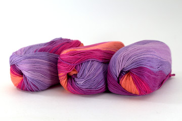 Three coils of sectional yarn for needlework on a white background close-up