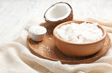 Fototapeta na wymiar Fresh coconut flakes in bowls on wooden background