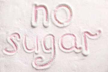 Phrase NO SUGAR written on sugar sand