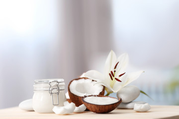Composition with coconut butter in glass jar and shell on blurred background