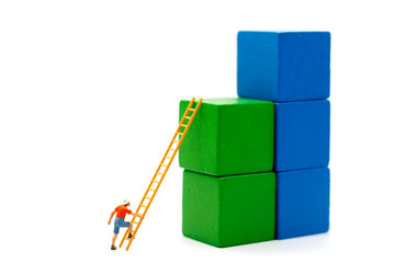 Obraz premium Miniature people: Climber looking up while challenging route on growth graph with wood ladder, Concept of the path to purpose and success.