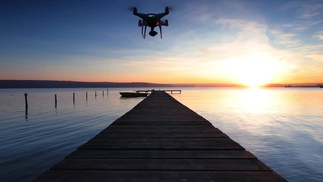 Drone flight over small dock and boat at the lake