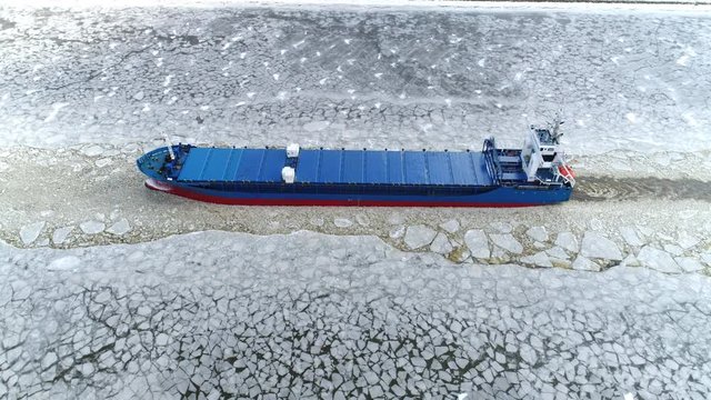 Cargo ship sailing through ice aerial shot