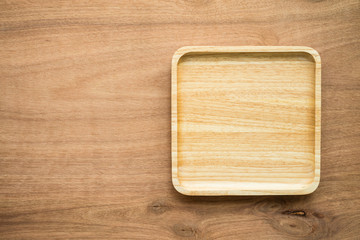 Top view of unused brand new brown handmade wooden dish plate on wooden table background