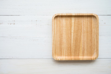 Top view of unused brand new brown handmade wooden dish plate on white wooden table background