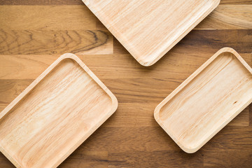 Top view of unused brand new brown handmade wooden kitchen utensil, dish plate on wooden table background