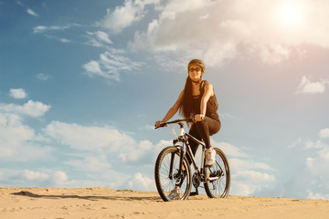 Happy young woman extreme riding bicycle outside. Healthy lifestyle. Fit cute girl wearing sportswear and helmet with backpack.