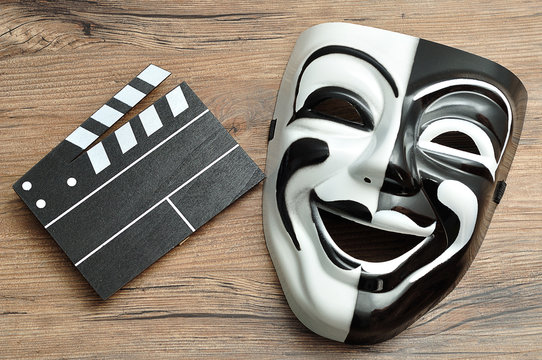 A Black And White Movie Board And A Theater Mask On A Wooden Background
