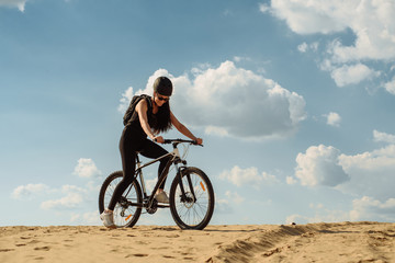 Healthy lifestyle. Female cyclist on a country road training for competition. Young woman riding bicycle on hill. Sport and vacation.