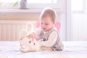 10 months old baby girl playing with a plush bunny