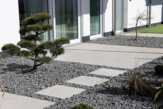 Kleiner Ziergarten mit grauen Terrassenplatten