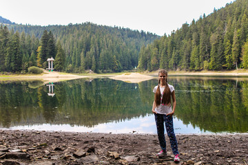 Fototapeta na wymiar Young woman walk near mountain lake, harmony concept