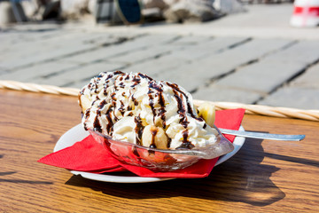 Eating delicious banana split ice cream at seaside walkpath.