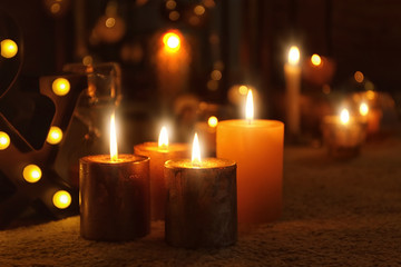Burning candles on floor indoors