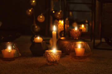 Burning candles on floor indoors