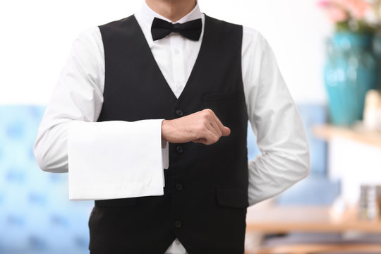 Waiter with towel on hand indoors