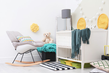 Beautiful interior of baby room with  crib and rocking chair