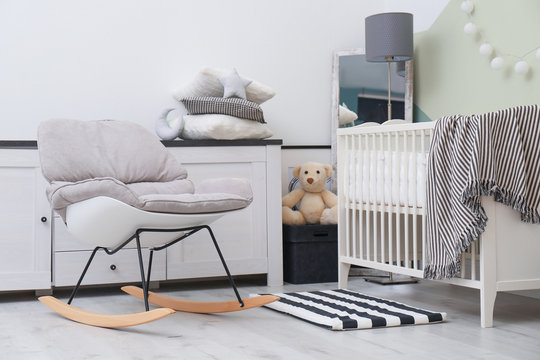 Beautiful interior of baby room with  crib and rocking chair