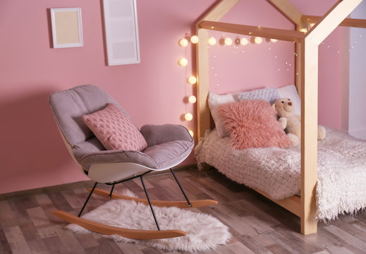 Comfortable bed and rocking chair in modern children room
