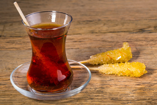 Close Up Of Saffron Rock Candy Sugar Crystal in Black Tea Cup Is Often Used To Be Dissolved In Tea In Iranian Persian Cuisine