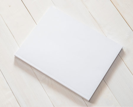 Blank book cover mockup template with page front side on white surface on wood table