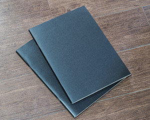 Black dark blank leather magazine cover book template on white grey wooden table background