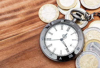 Pocket watch with euro coins on the table. Business concept. Copy space.