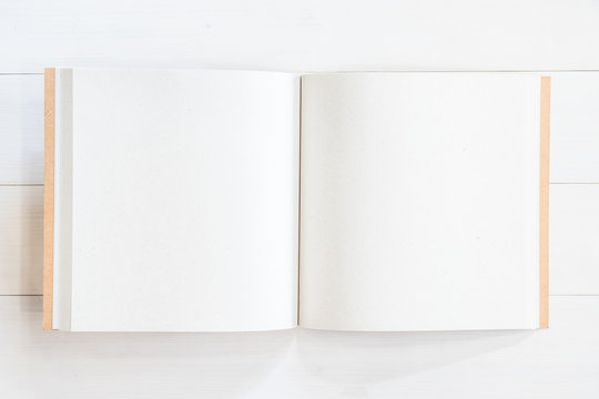 Blank book mockup template square-size catalog or magazine with open pages on white wood table