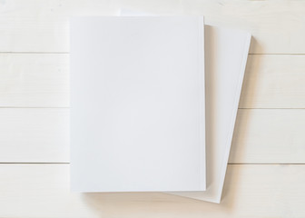 Blank book cover template with page in front side standing on white wood background flat lay.