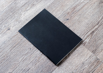 Black dark blank leather magazine cover book template on white grey wooden table background