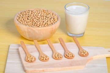 soy milk and soy seeds in wooden bowl