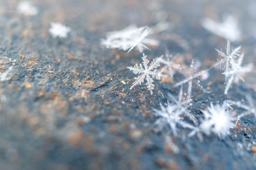 close-up of snowflakes on metallic slightly rusty texture background, winter cold