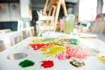 Palette of an artist with some vibrant colors for mixing in studio of painting