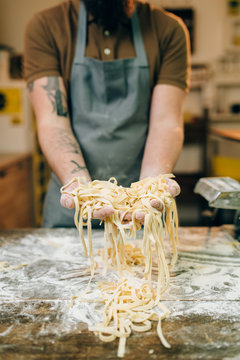 Male chef hands with uncooked homemade pasta