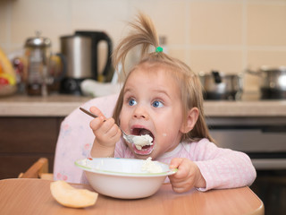 1,5 years old girl eating by herself