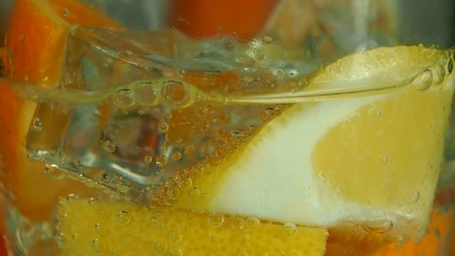 Fresh and juicy citrus fruits ice cubes are ready for cold soda. Bubbles are goes to the surface.
