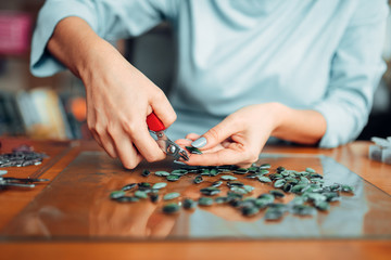Female person hands with pliers, handmade jewelry