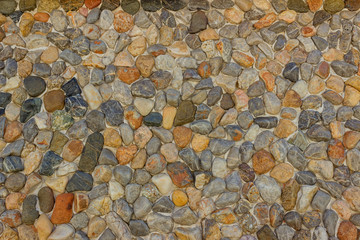  Wall of small multicolored pebbles. The stone surface of the wall or the road. Background, texture.