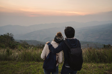 Fototapeta premium Loving couple embracing on the mountain at sunset.