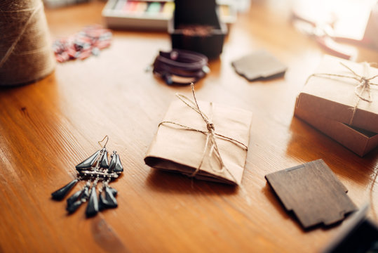 Gift box and handmade earrings on wooden table
