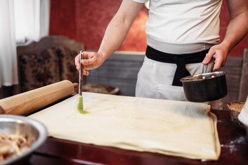 Male chef cooking apple strudel on the kitchen
