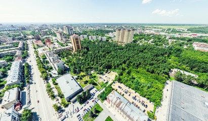 Aerial city view with crossroads and roads, houses, buildings, parks and parking lots, bridges. Helicopter drone shot. Wide Panoramic image.